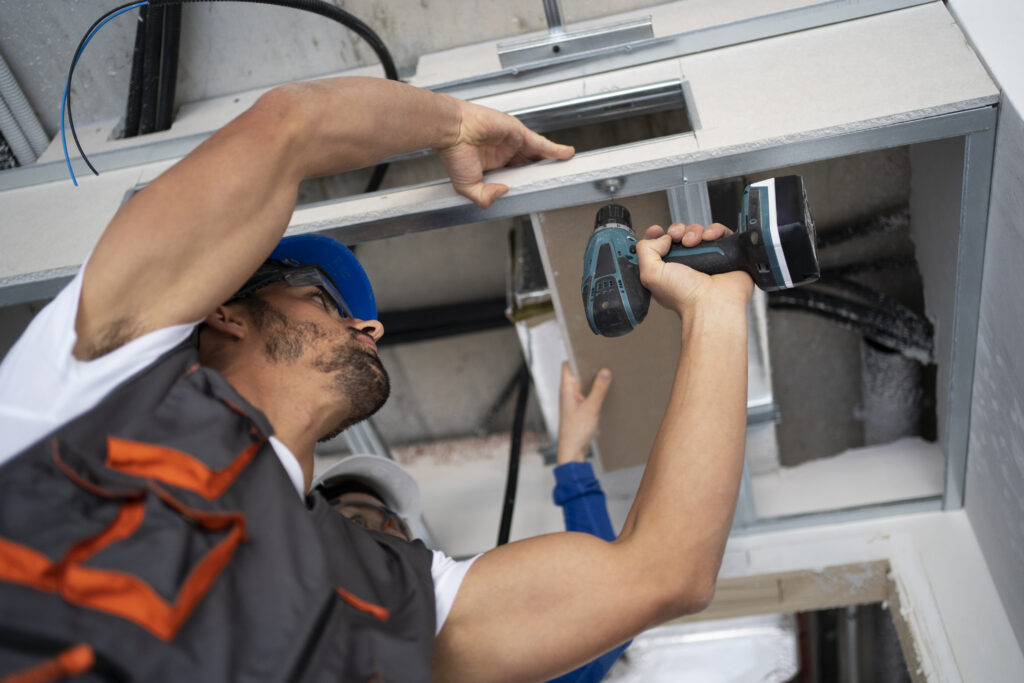 a man working with a drill - pete's garage door repair in grand bend